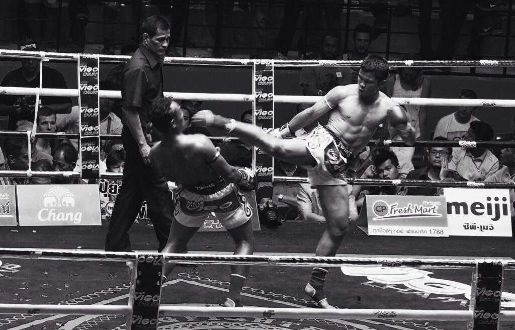 Saenchai leaning back to dodge a kick from fellow Muay Thai legend Nong-O Gaiyanghadaogym.